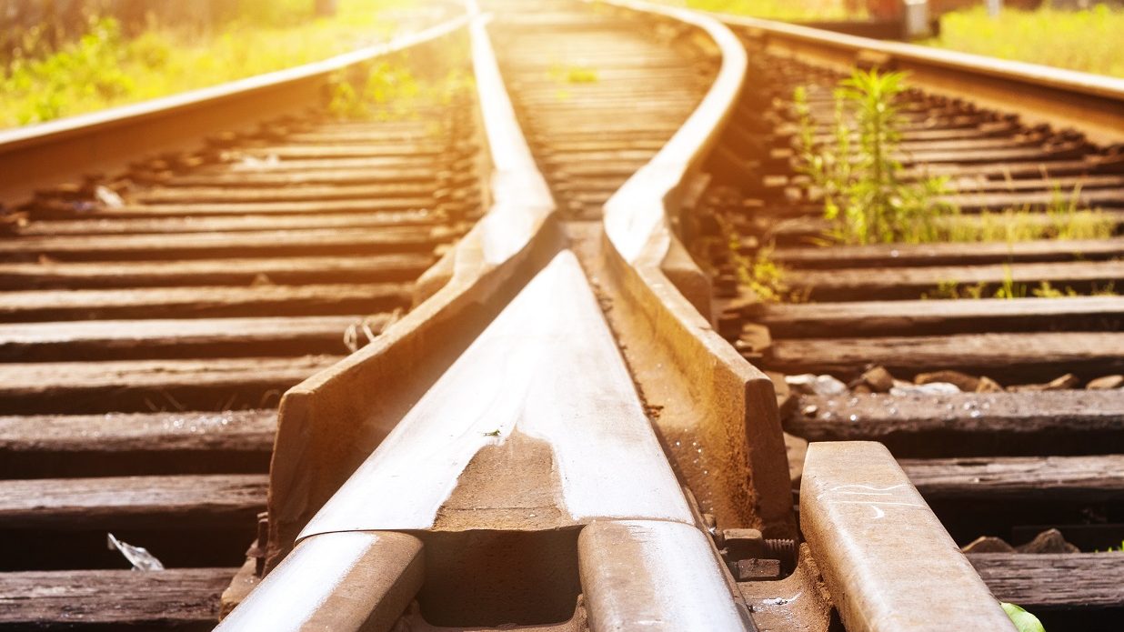 Un aiguillage ferroviaire au petit matin, deux voies qui divergent